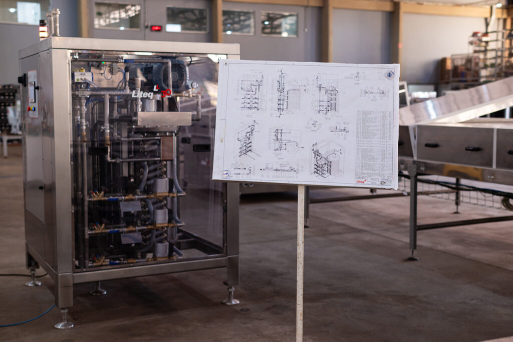 Máquina industrial para chocolate ao lado de planta técnica